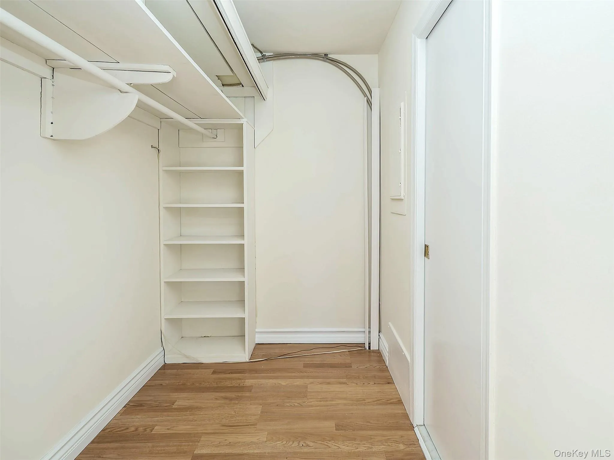 Spacious closet with light wood-style floors Spacious closet with light wood-style floors