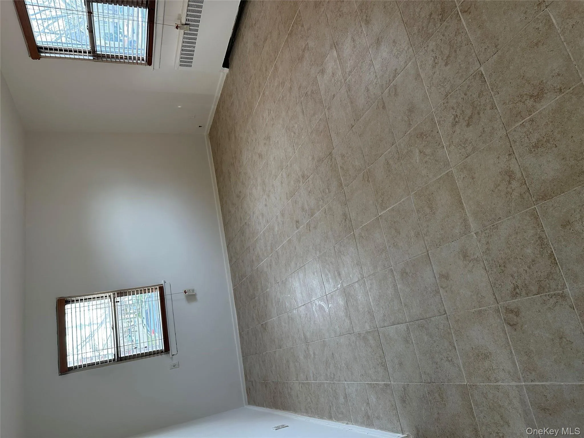 Spare room featuring radiator heating unit and light tile patterned floors Spare room featuring radiator heating unit and light tile patterned floors