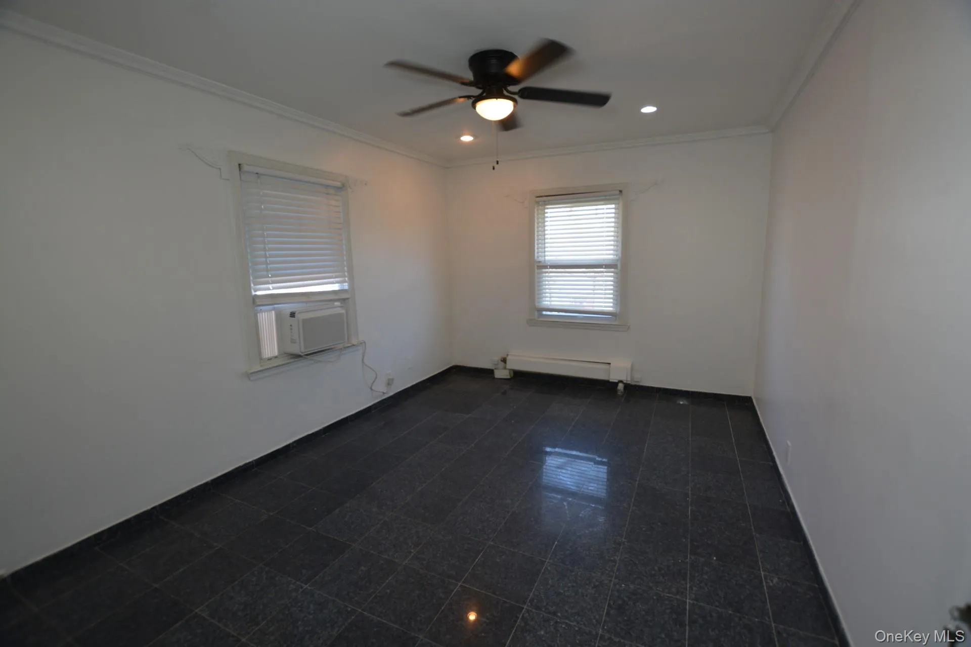 Spare room featuring ornamental molding, a ceiling fan, recessed lighting, a baseboard heating unit, and cooling unit Spare room featuring ornamental molding, a ceiling fan, recessed lighting, a baseboard heating unit, and cooling unit
