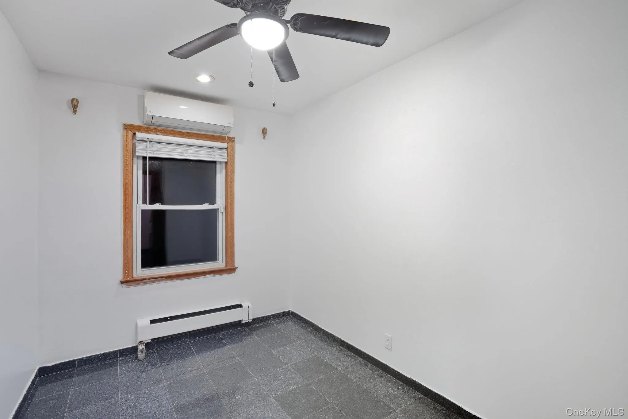 Unfurnished room featuring a baseboard heating unit, an AC wall unit, and recessed lighting Unfurnished room featuring a baseboard heating unit, an AC wall unit, and recessed lighting