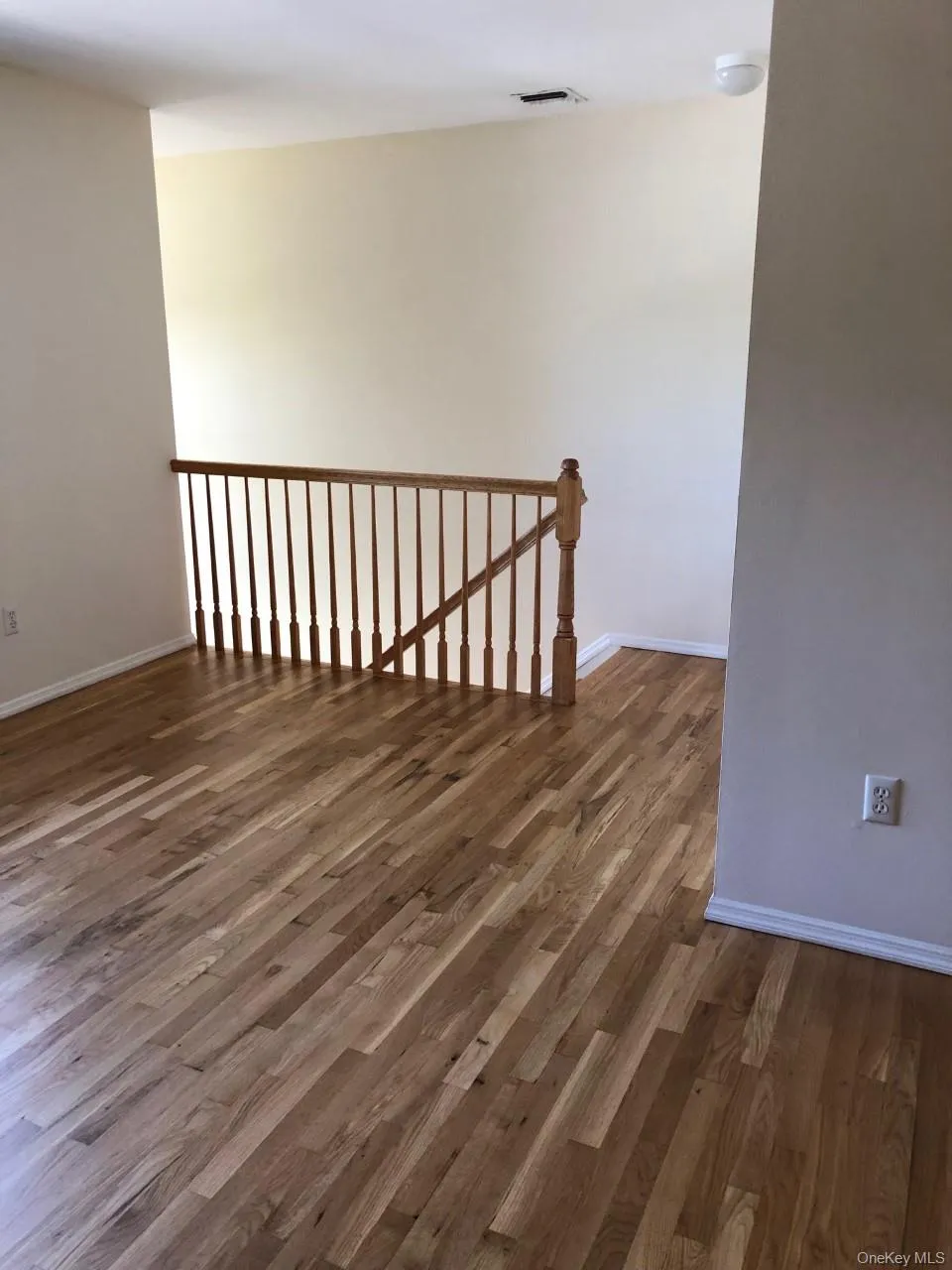 Empty room with dark wood-style flooring and baseboards Empty room with dark wood-style flooring and baseboards