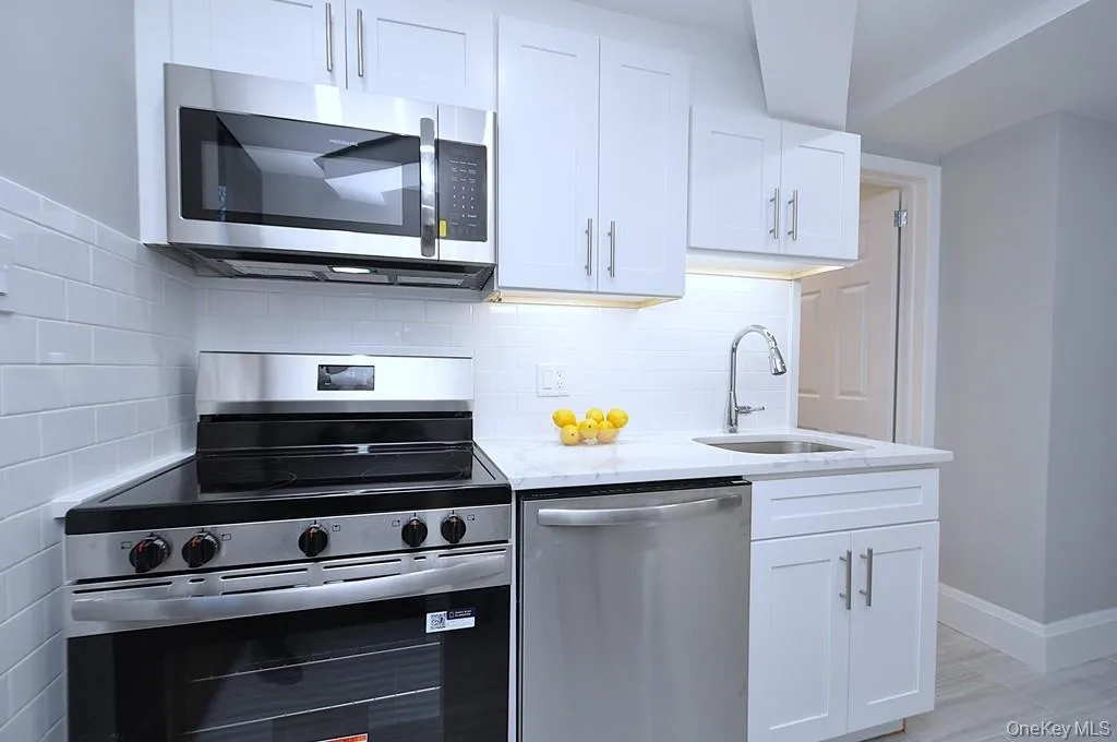 Fully renovated eat-in-kitchen has quartz counters, stainless steel appliances including a dishwasher, microwave, range and refrigerator. The white cabinets and pantry provide plenty of storage for the chef in you. The counter offer a place to have a meal with pendant lighting. The kitchen is approx 15' x 7'-4". Fully renovated eat-in-kitchen has quartz counters, stainless steel appliances including a dishwasher, microwave, range and refrigerator. The white cabinets and pantry provide plenty of storage for the chef in you. The counter offer a place to have a meal with pendant lighting. The kitchen is approx 15' x 7'-4".