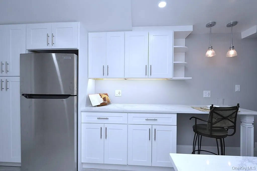 Fully renovated eat-in-kitchen has quartz counters, stainless steel appliances including a dishwasher, microwave, range and refrigerator. The white cabinets and pantry provide plenty of storage for the chef in you. The counter offer a place to have a meal with pendant lighting. The kitchen is approx 15' x 7'-4". Fully renovated eat-in-kitchen has quartz counters, stainless steel appliances including a dishwasher, microwave, range and refrigerator. The white cabinets and pantry provide plenty of storage for the chef in you. The counter offer a place to have a meal with pendant lighting. The kitchen is approx 15' x 7'-4".