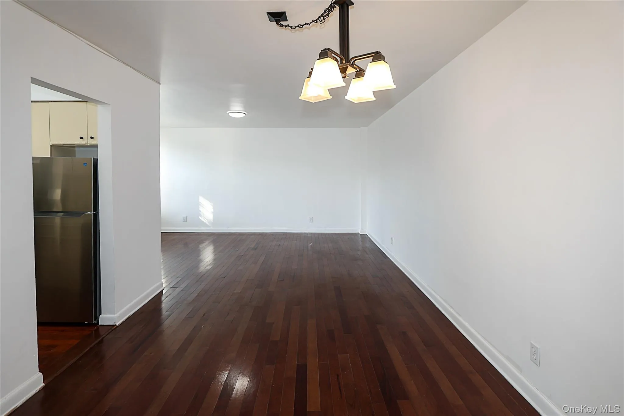 Unfurnished dining area with dark wood finished floors and a chandelier Unfurnished dining area with dark wood finished floors and a chandelier