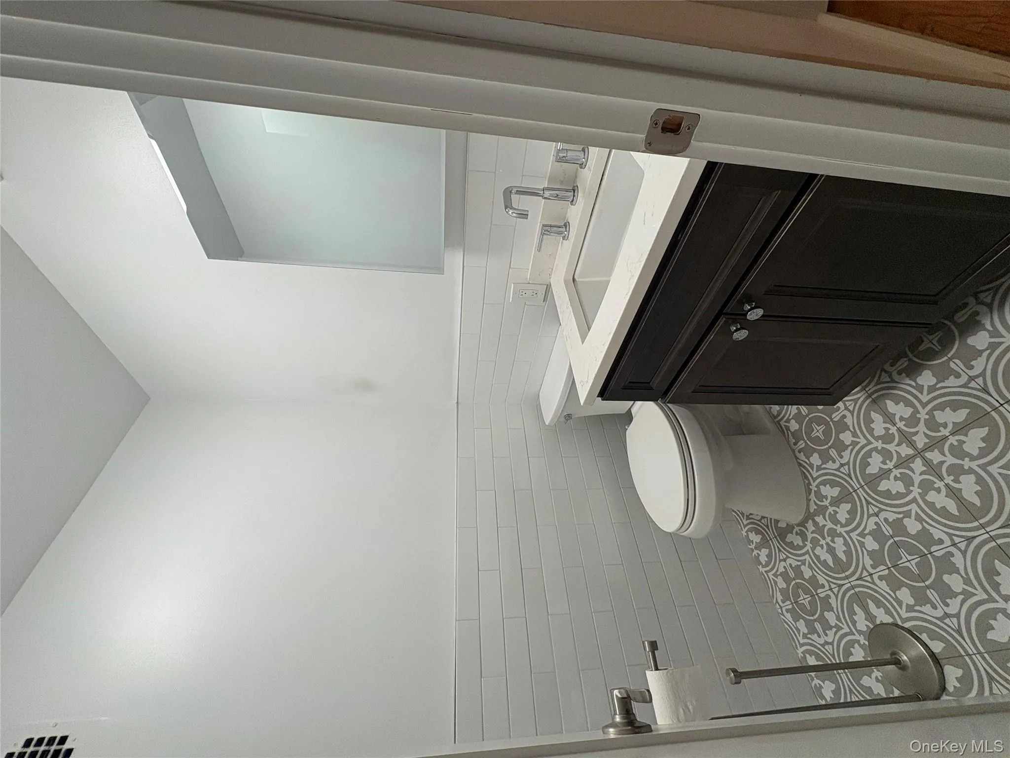 Half bath with vanity, tile walls, wainscoting, and light tile patterned floors Half bath with vanity, tile walls, wainscoting, and light tile patterned floors