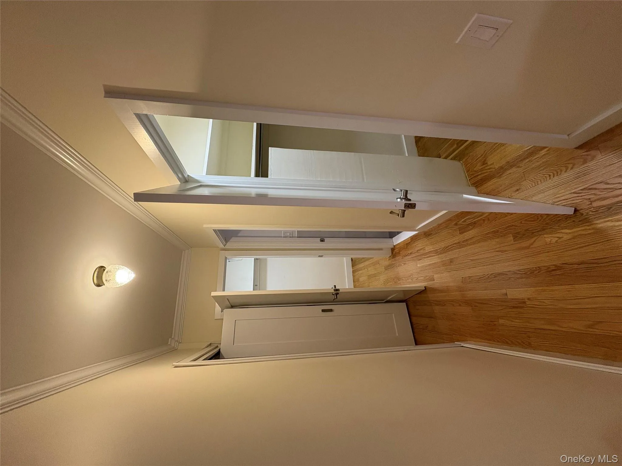 Hallway with light wood-style floors and crown molding Hallway with light wood-style floors and crown molding