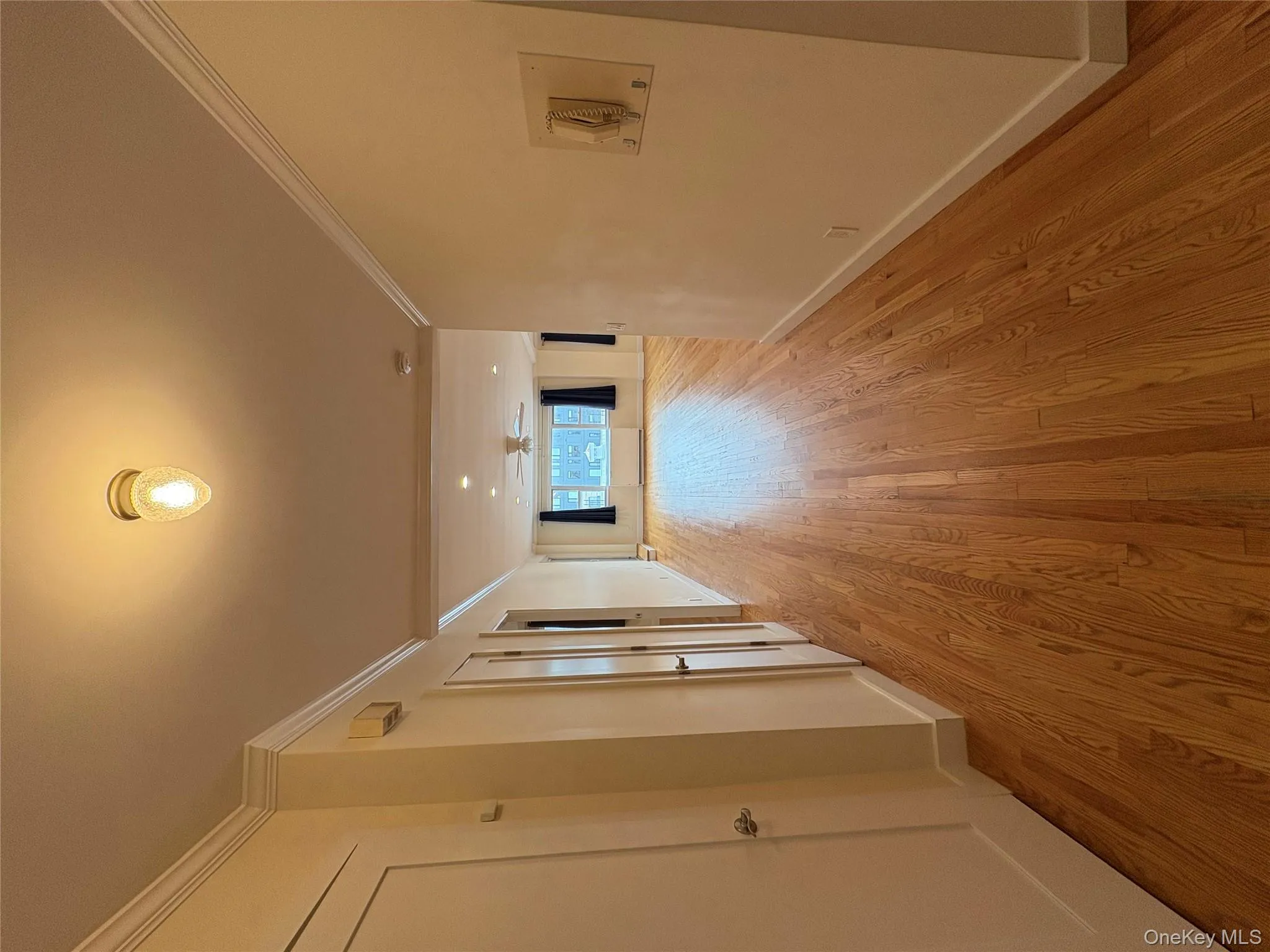Corridor with light wood-style floors and crown molding Corridor with light wood-style floors and crown molding