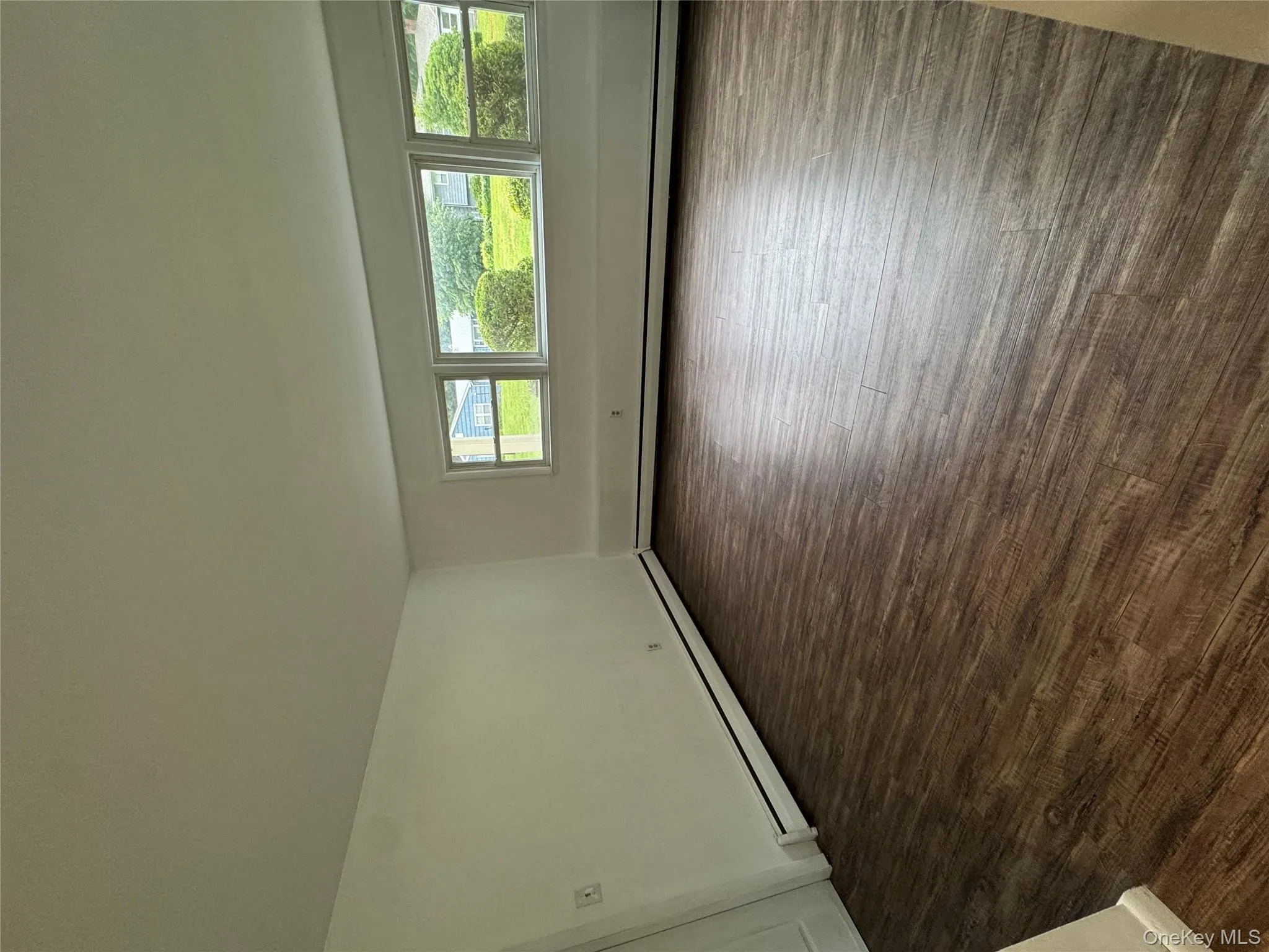 Spare room featuring dark wood-style floors and a baseboard heating unit Spare room featuring dark wood-style floors and a baseboard heating unit