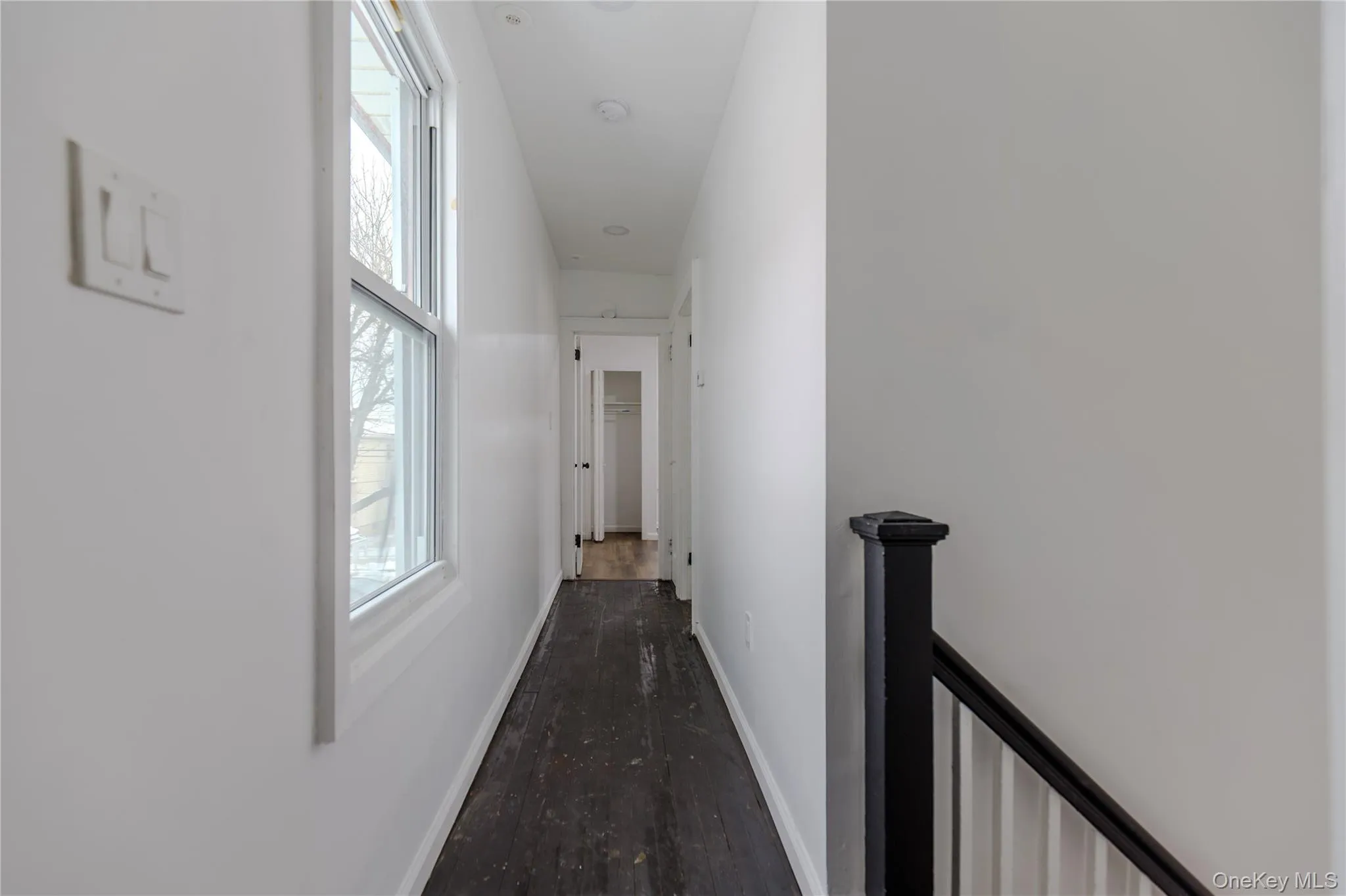 Hall with an upstairs landing and dark wood-type flooring Hall with an upstairs landing and dark wood-type flooring