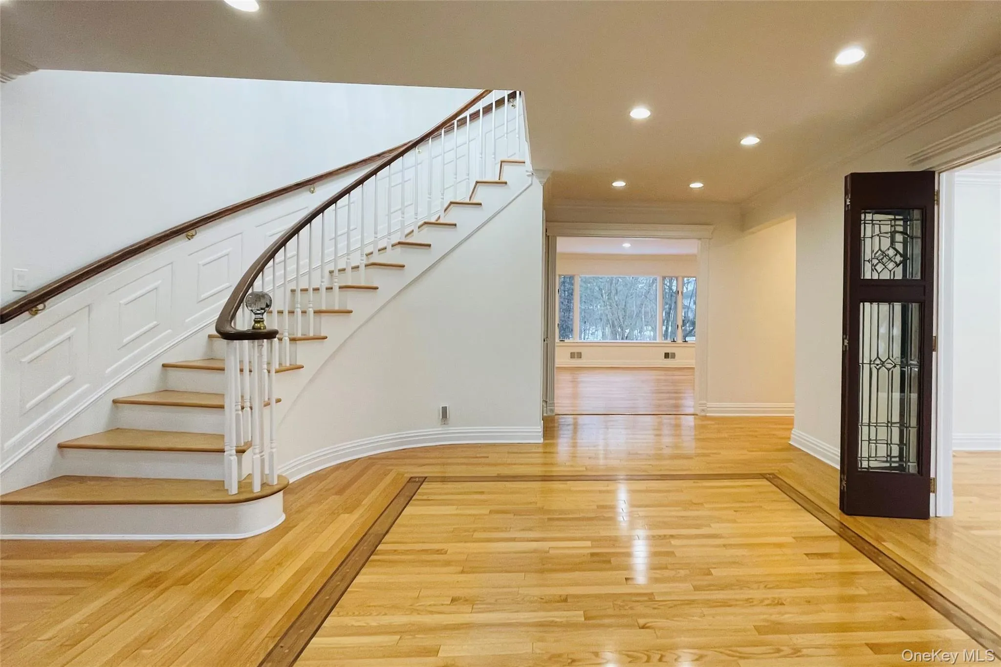 Stairway with hardwood / wood-style floors, recessed lighting, and ornamental molding Stairway with hardwood / wood-style floors, recessed lighting, and ornamental molding