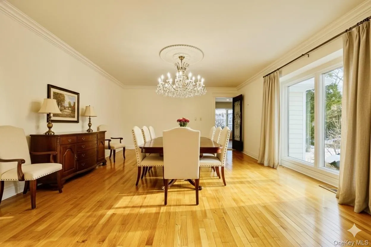 Dining room virtually staged featuring crown molding, light wood-style flooring, and a chandelier Dining room virtually staged featuring crown molding, light wood-style flooring, and a chandelier