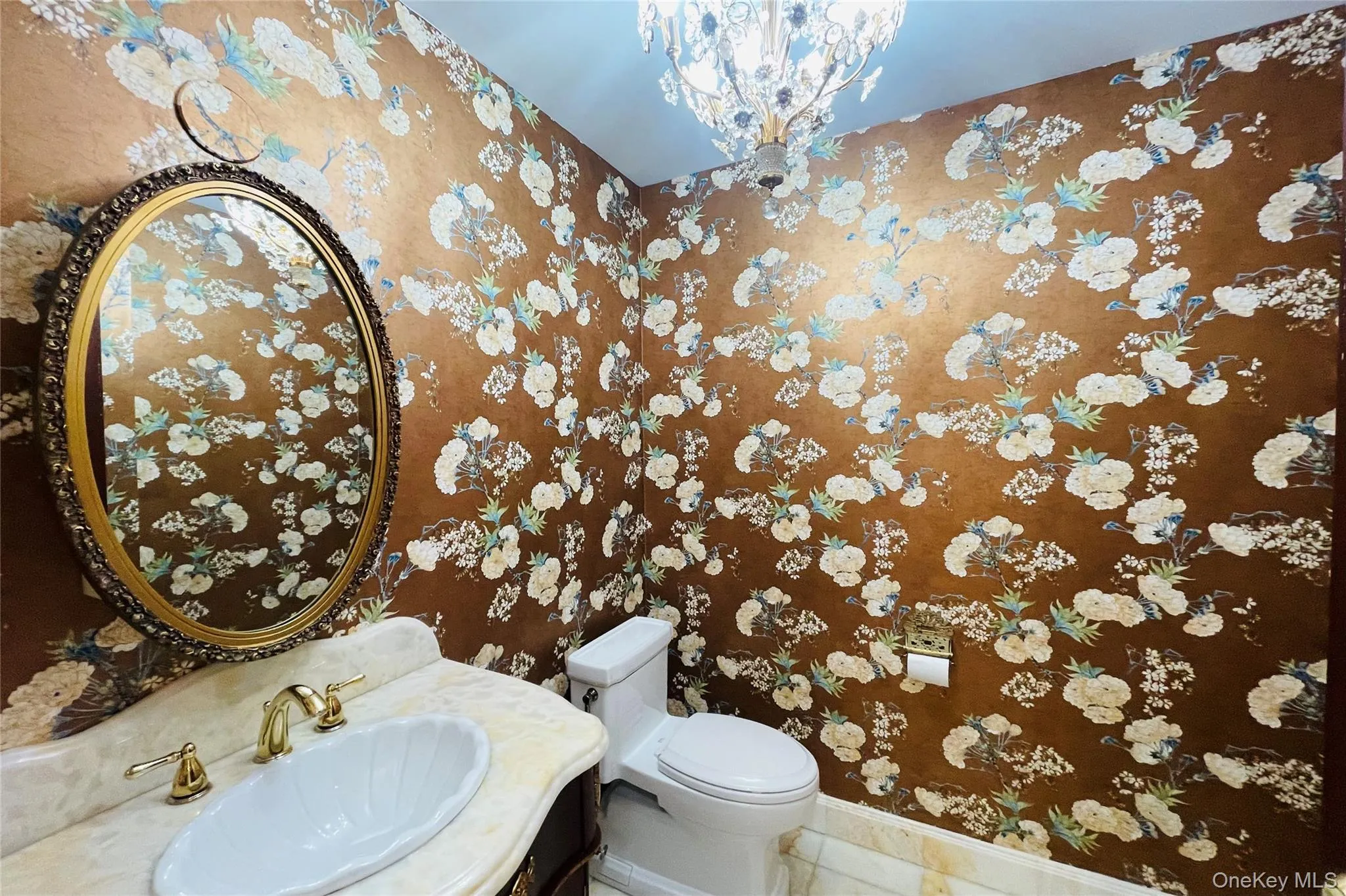 Half bath featuring vanity and a chandelier Half bath featuring vanity and a chandelier