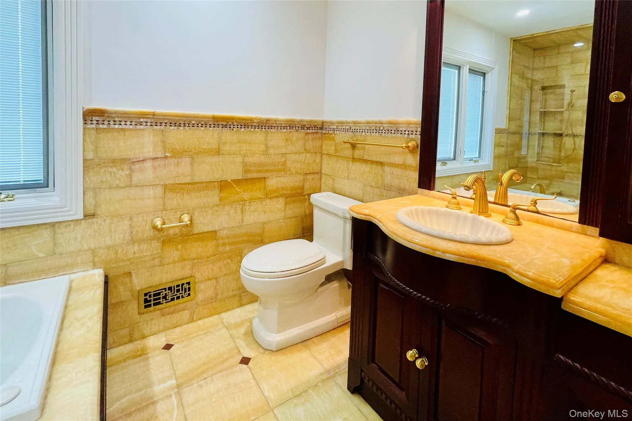 Primary Bathroom featuring vanity, a bath, tile patterned floors, tile walls, and wainscoting Primary Bathroom featuring vanity, a bath, tile patterned floors, tile walls, and wainscoting