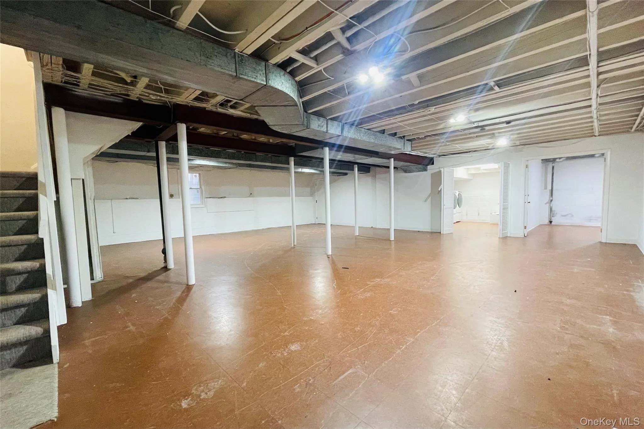 Finished basement with tile patterned floors, laundry room and storage room Finished basement with tile patterned floors, laundry room and storage room