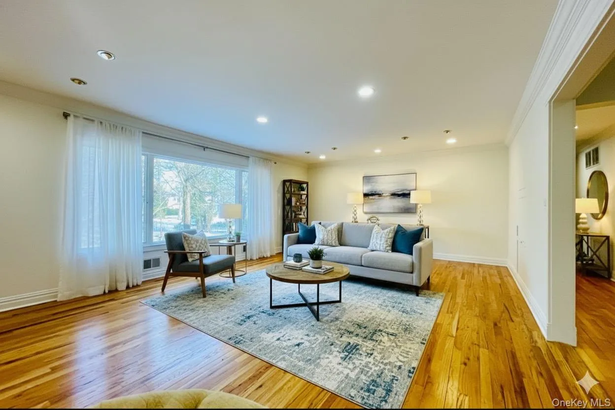 Living room virtually staged with ornamental molding, light wood-style flooring, and recessed lighting Living room virtually staged with ornamental molding, light wood-style flooring, and recessed lighting