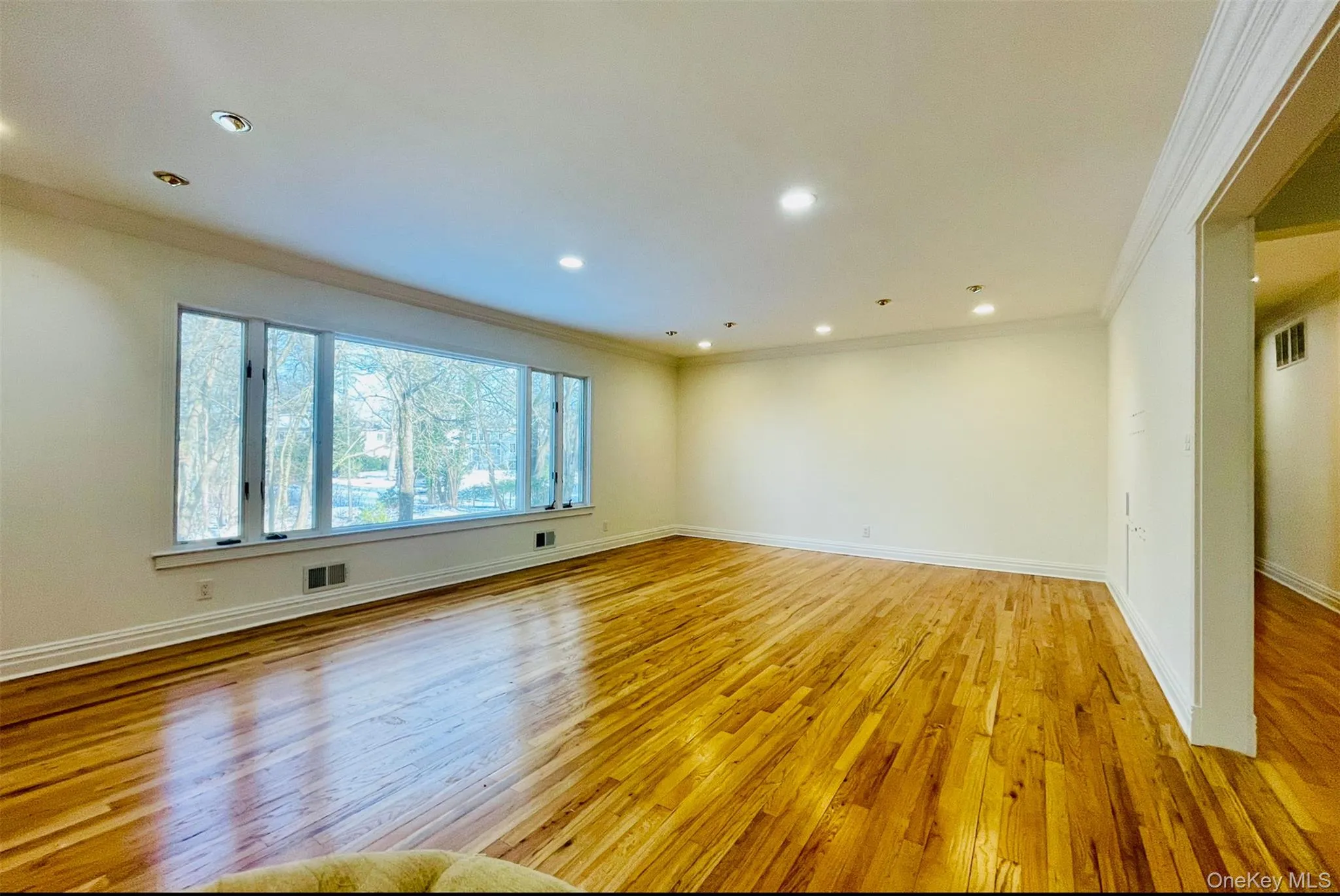 Empty room with ornamental molding, light wood-type flooring, and recessed lighting Empty room with ornamental molding, light wood-type flooring, and recessed lighting