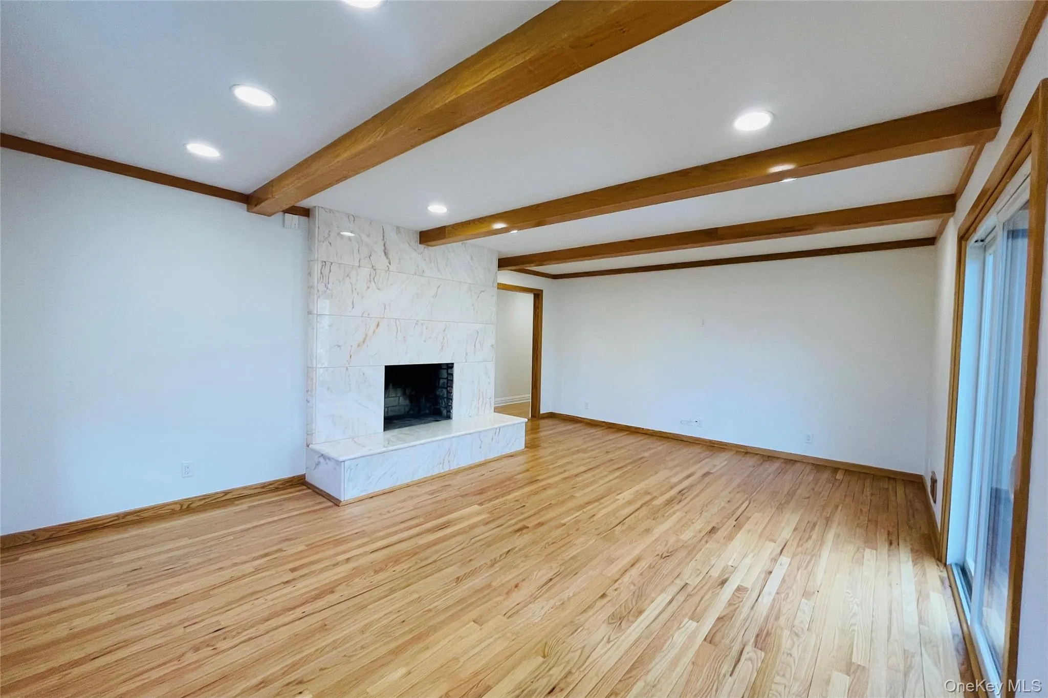 Unfurnished living room featuring recessed lighting, a tile fireplace, light wood-style floors, and beamed ceiling Unfurnished living room featuring recessed lighting, a tile fireplace, light wood-style floors, and beamed ceiling