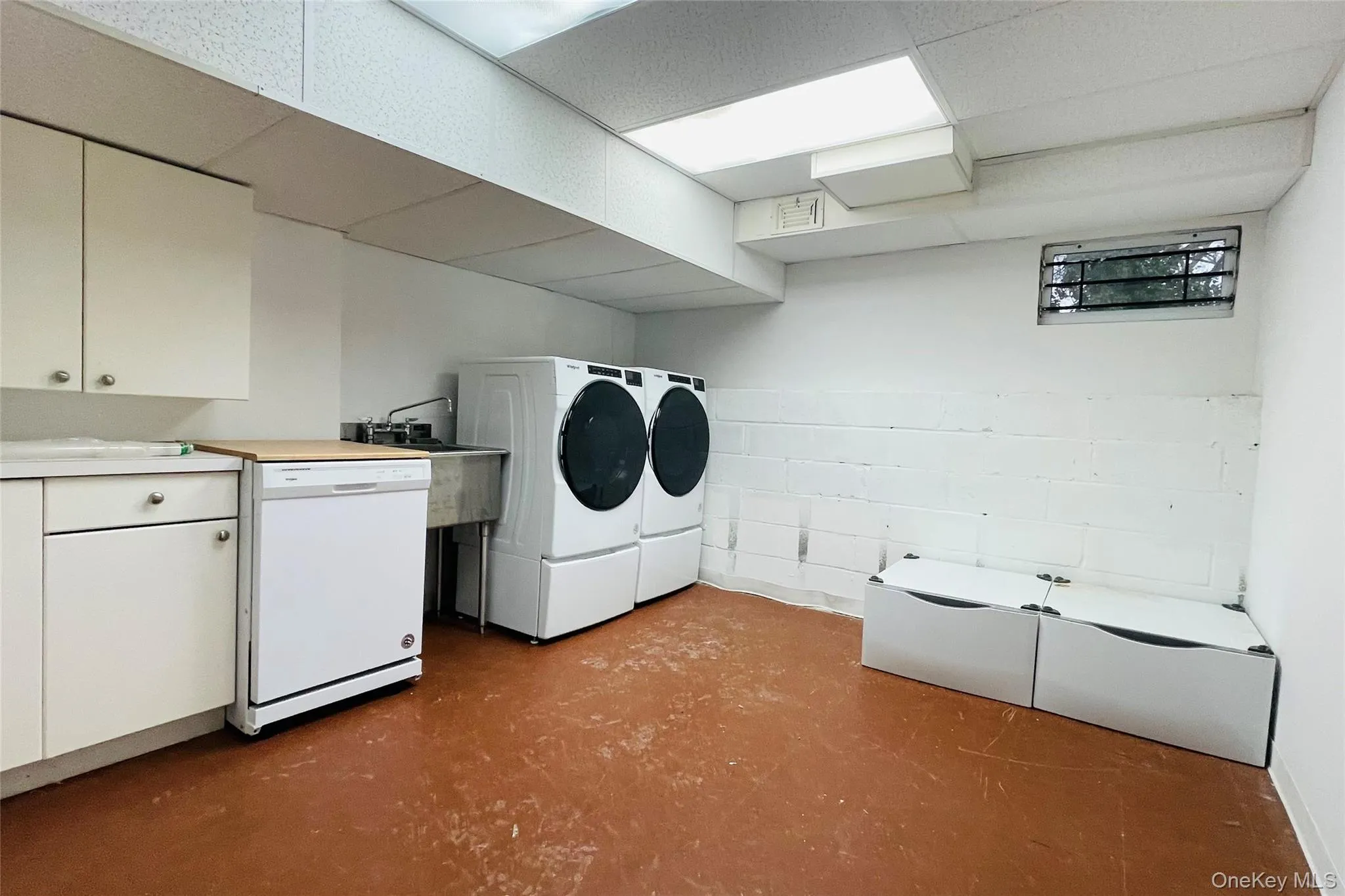 Laundry in basement, with additional dishwasher, more cabinets, and washer and dryer Laundry in basement, with additional dishwasher, more cabinets, and washer and dryer