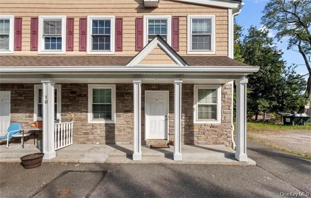 Entrance to property featuring stone siding, a shingled roof, and covered porch Entrance to property featuring stone siding, a shingled roof, and covered porch