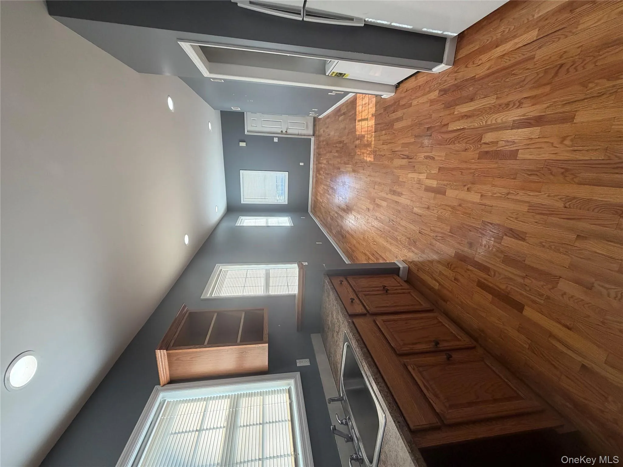 Kitchen featuring open shelves, recessed lighting, dark countertops, brown cabinets, and light wood-style flooring Kitchen featuring open shelves, recessed lighting, dark countertops, brown cabinets, and light wood-style flooring
