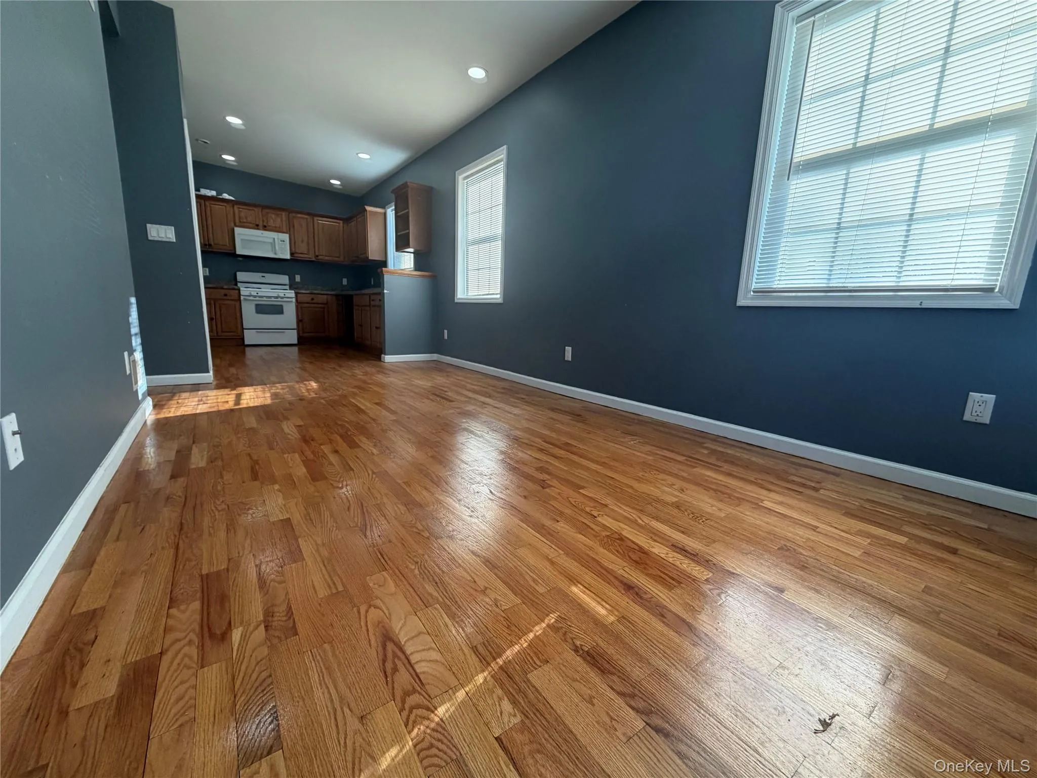 Unfurnished living room with dark wood finished floors and recessed lighting Unfurnished living room with dark wood finished floors and recessed lighting