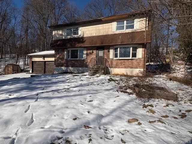 View of front of property featuring a garage and brick siding View of front of property featuring a garage and brick siding