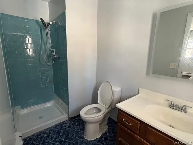 Bathroom featuring a shower stall and vanity Bathroom featuring a shower stall and vanity