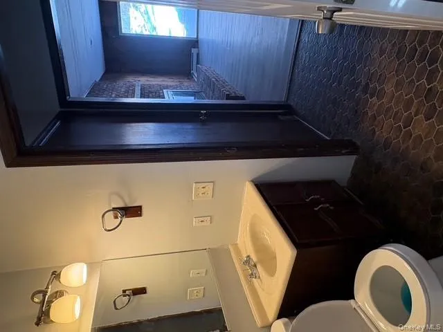 Bathroom featuring vanity and baseboard heating Bathroom featuring vanity and baseboard heating