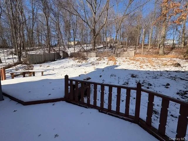 Yard covered in snow featuring a deck Yard covered in snow featuring a deck