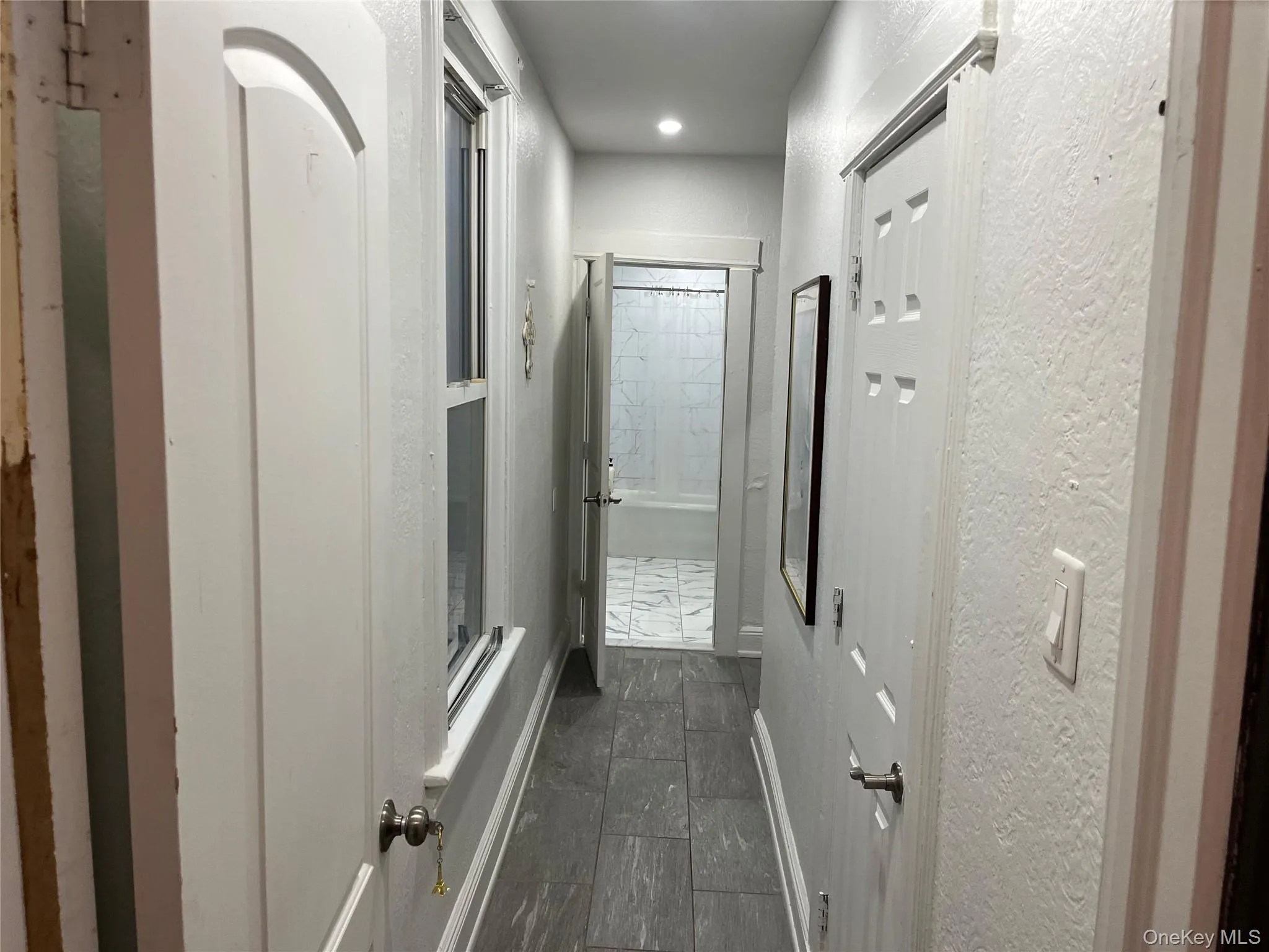 Hallway with a textured wall and recessed lighting Hallway with a textured wall and recessed lighting