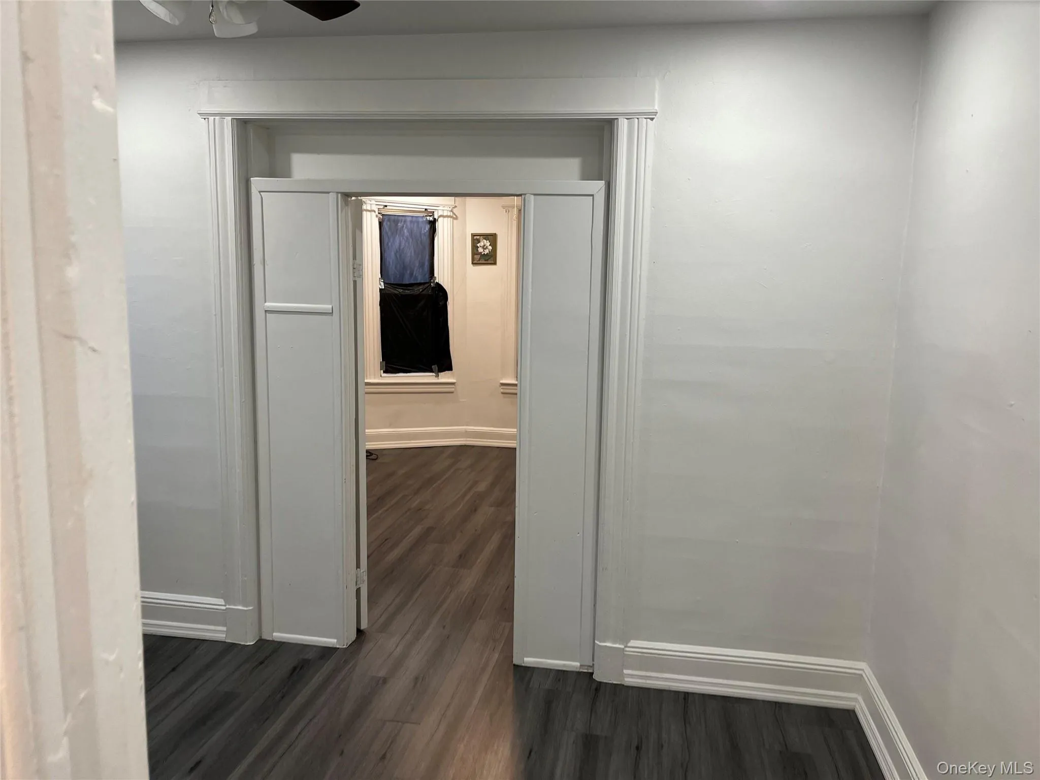 Hall with dark wood-style flooring and baseboards Hall with dark wood-style flooring and baseboards