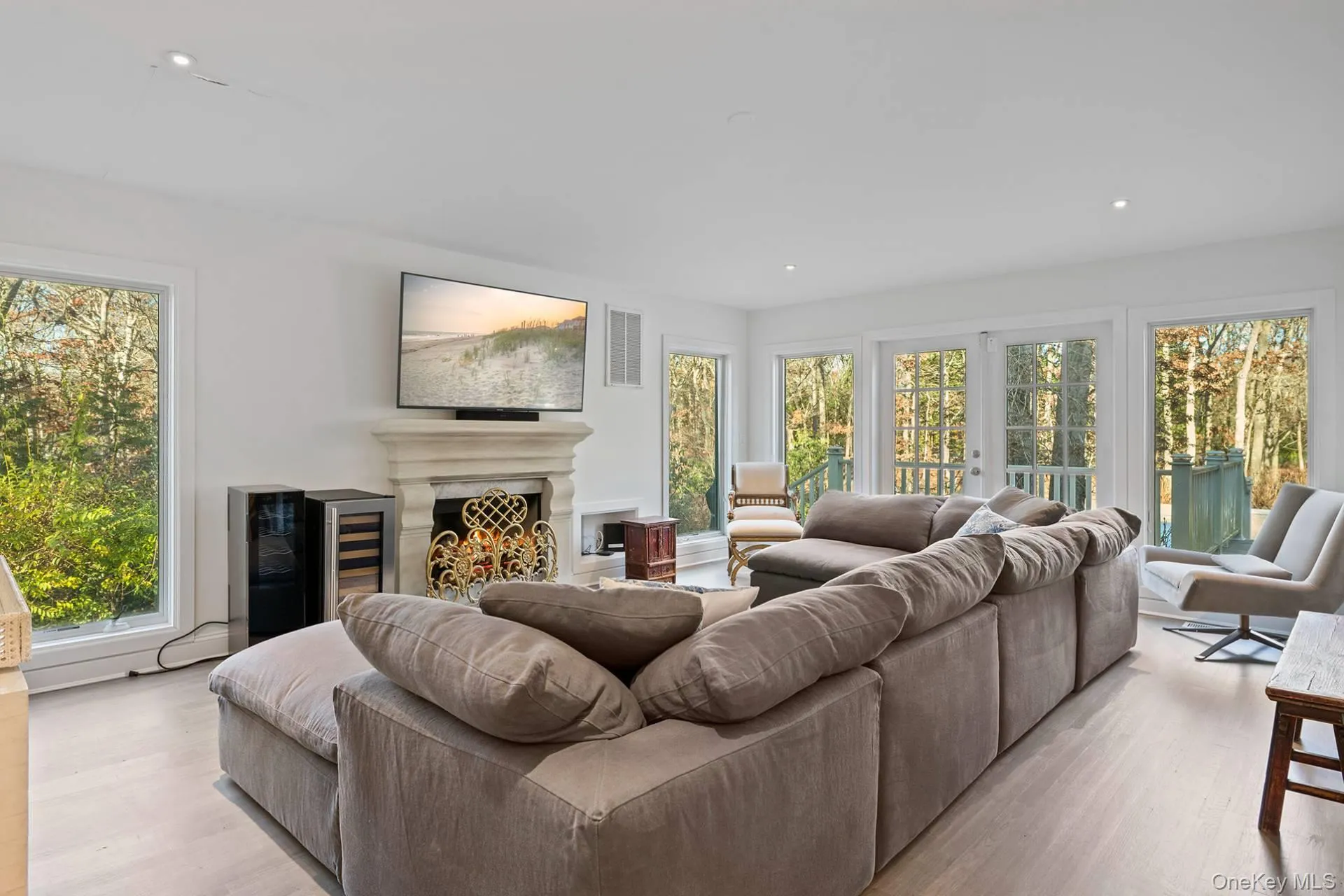 Living area featuring recessed lighting, light wood-style floors, and a warm lit fireplace