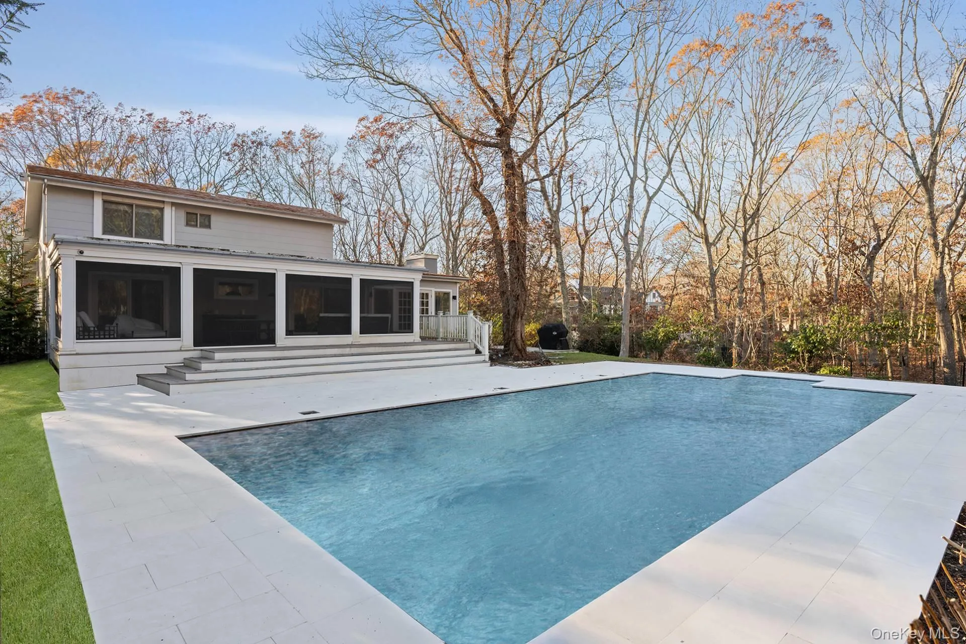 Outdoor pool with a sunroom and a patio area