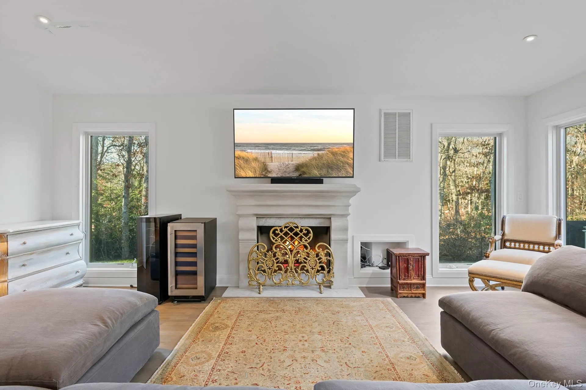 Living room featuring wine cooler, a fireplace with flush hearth, recessed lighting, and wood finished floors