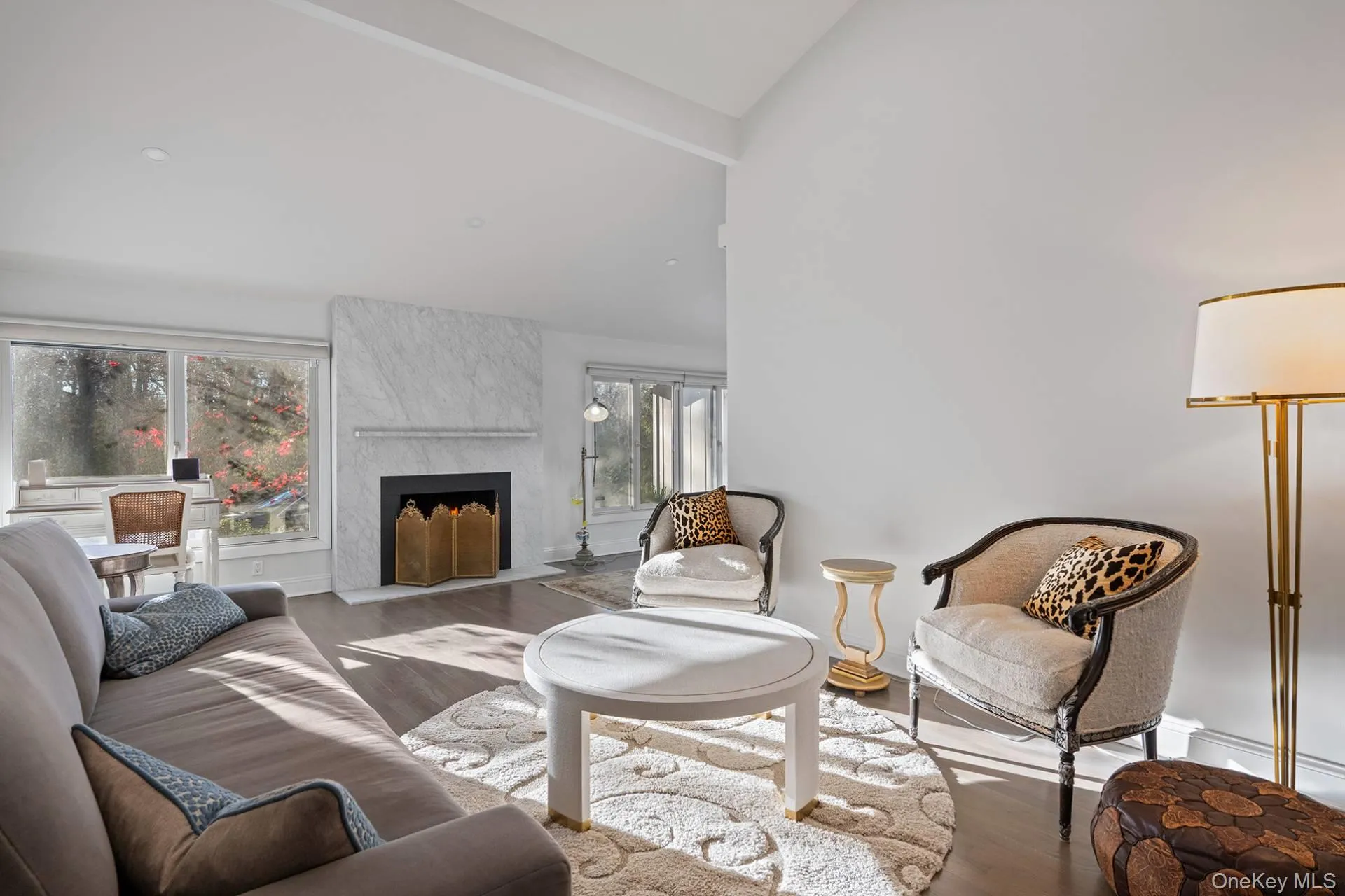 Living room featuring beam ceiling, a high end fireplace, wood finished floors, and high vaulted ceiling