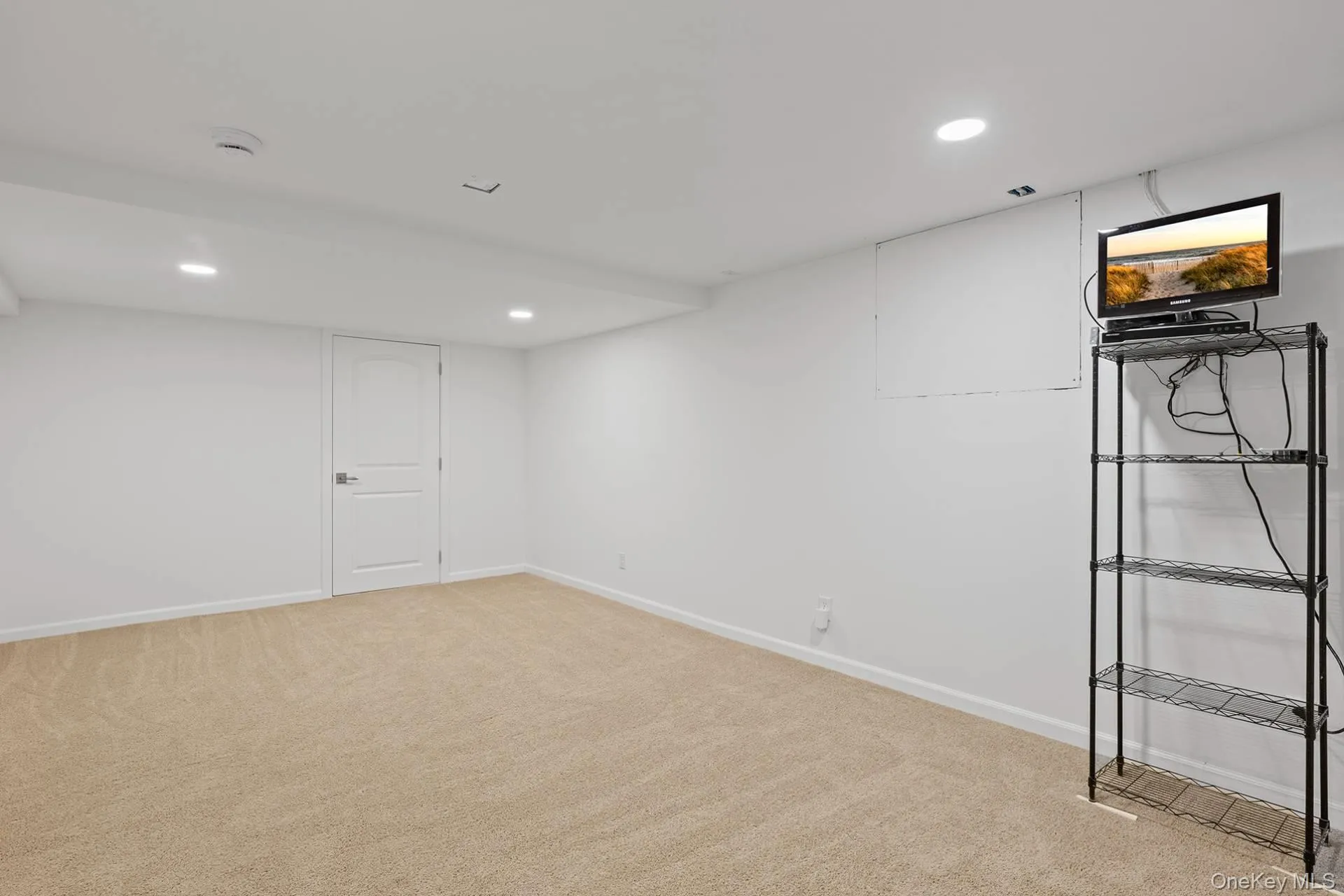 Finished below grade area with recessed lighting and light colored carpet