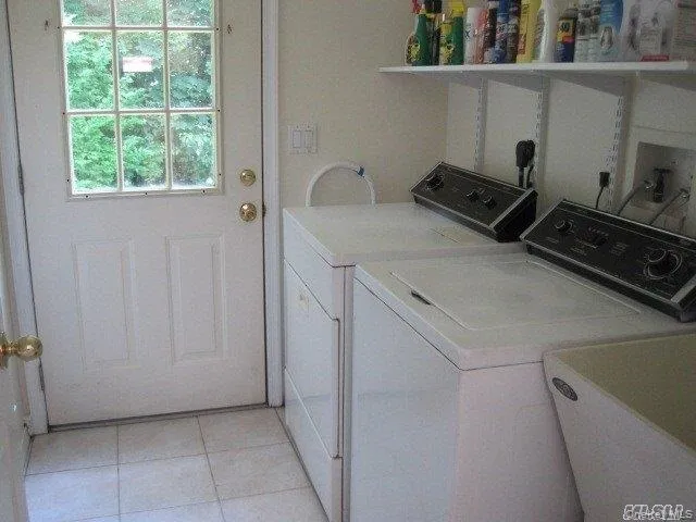 Laundry room featuring washing machine and clothes dryer and light tile patterned flooring Laundry room featuring washing machine and clothes dryer and light tile patterned flooring