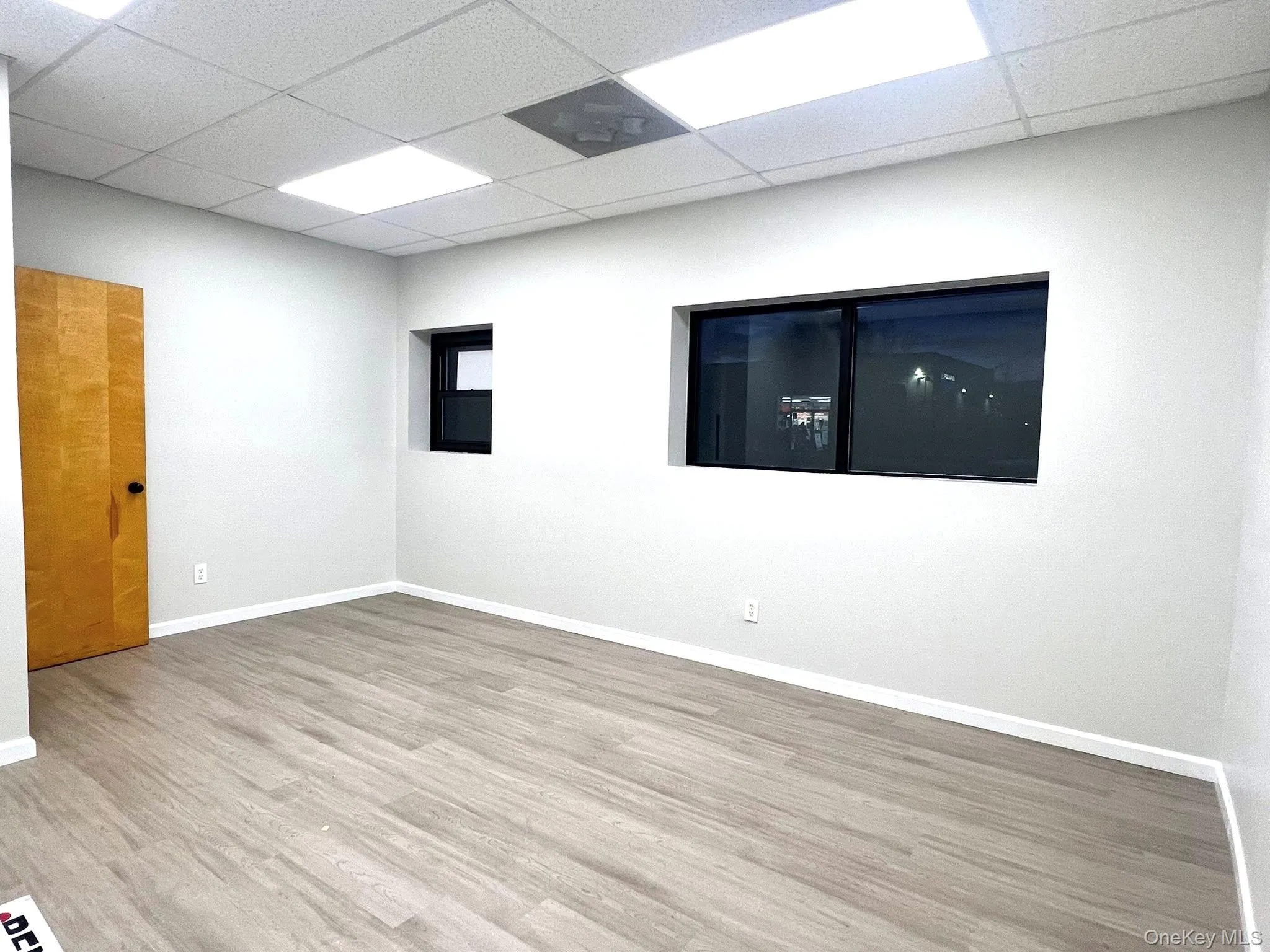 Spare room with wood finished floors and a drop ceiling Spare room with wood finished floors and a drop ceiling