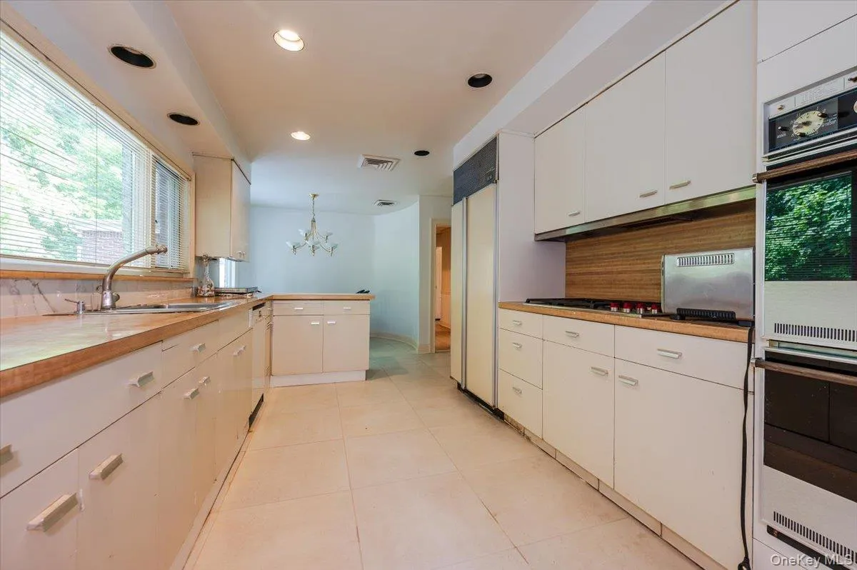 Kitchen featuring healthy amount of natural light, double wall oven, a chandelier, hanging light fixtures, and recessed lighting Kitchen featuring healthy amount of natural light, double wall oven, a chandelier, hanging light fixtures, and recessed lighting