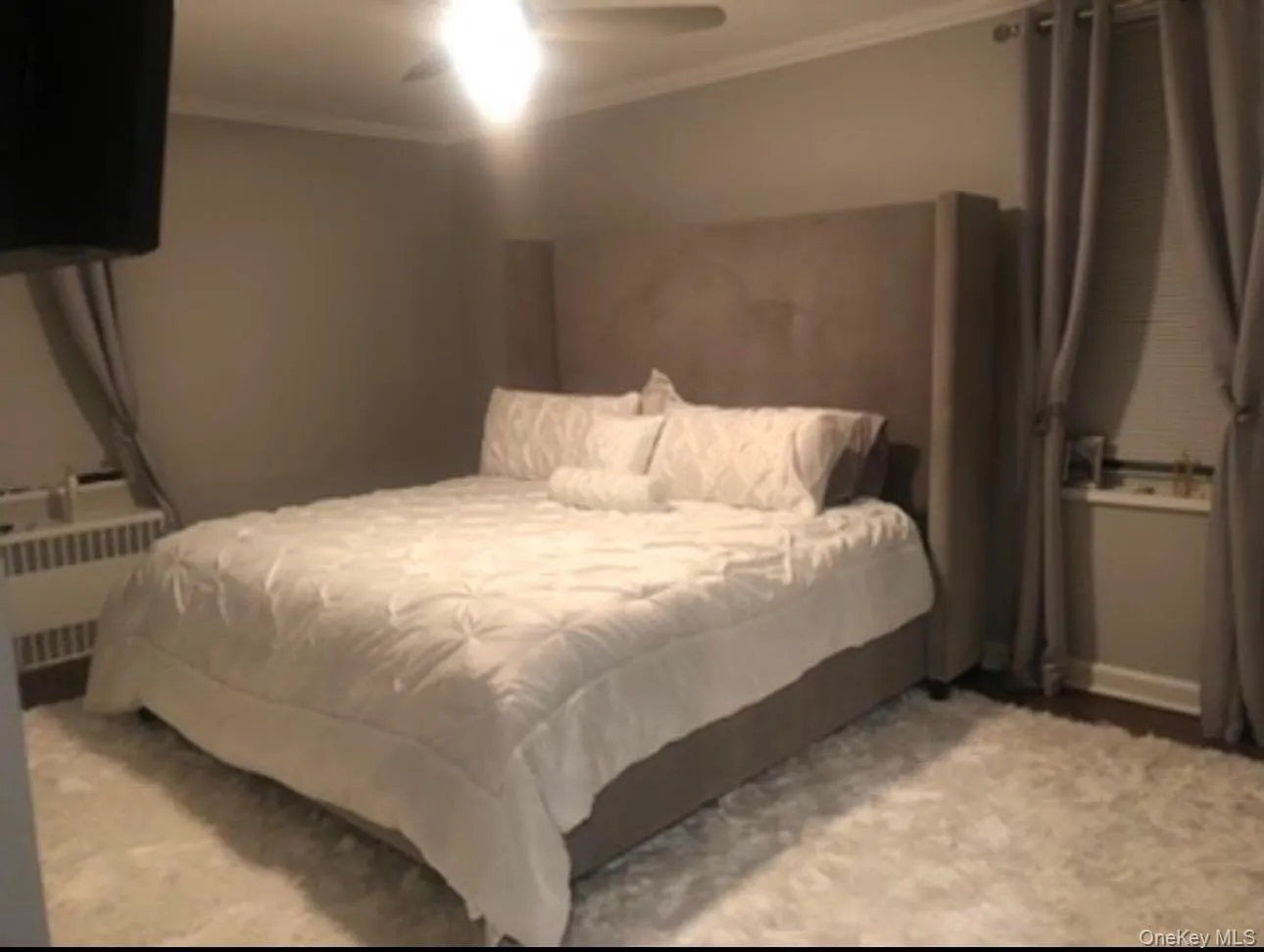 Bedroom with crown molding, radiator heating unit, and a ceiling fan Bedroom with crown molding, radiator heating unit, and a ceiling fan