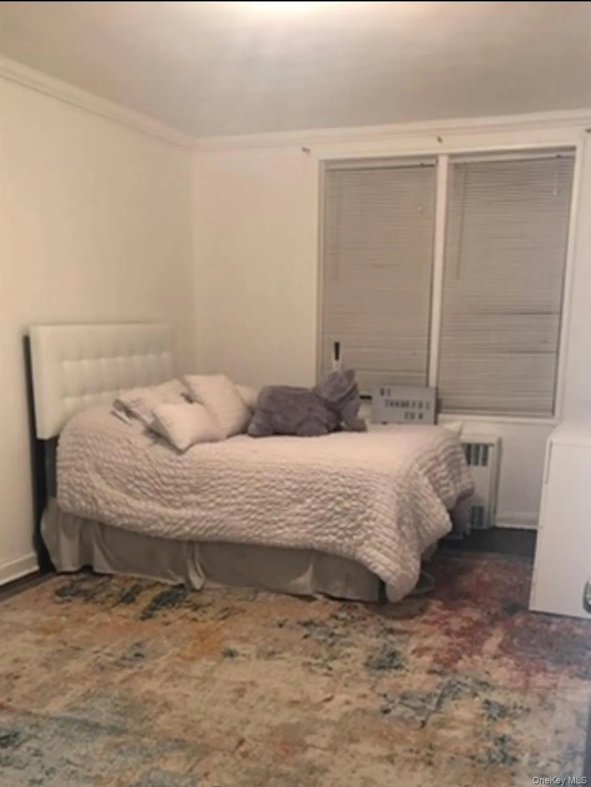 Bedroom with radiator heating unit and ornamental molding Bedroom with radiator heating unit and ornamental molding