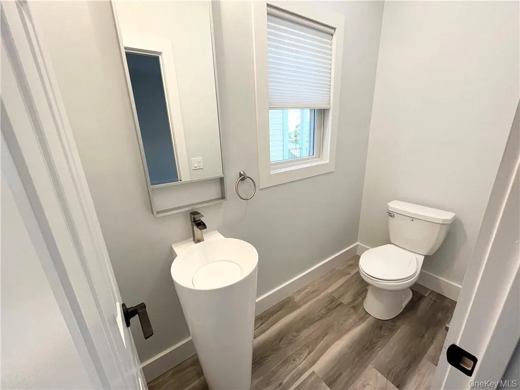 Bathroom featuring wood finished floors and baseboards Bathroom featuring wood finished floors and baseboards