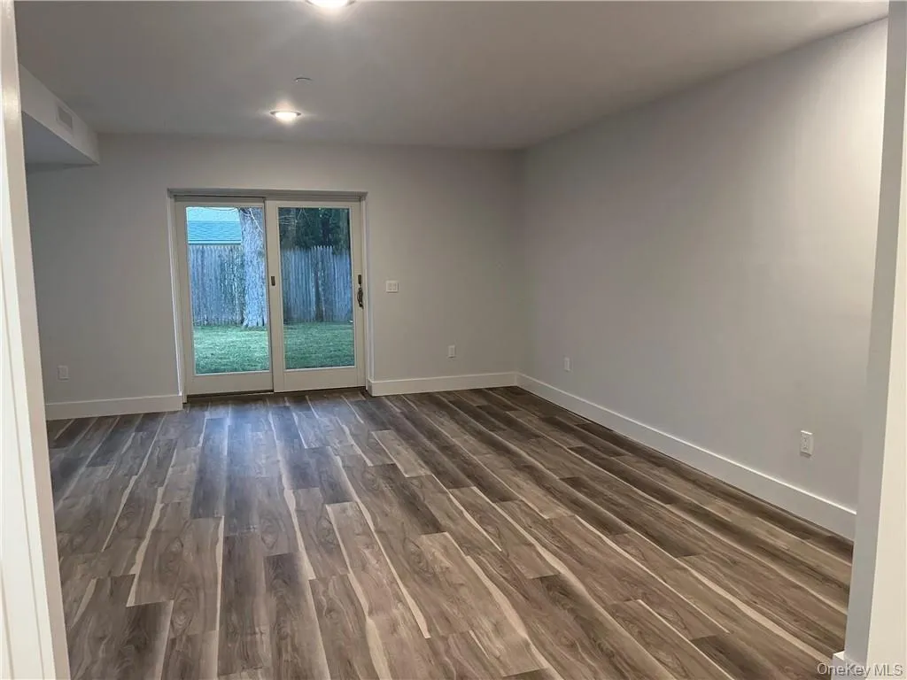 Spare room with dark wood finished floors and baseboards Spare room with dark wood finished floors and baseboards