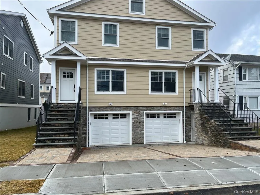 View of front of property featuring driveway, an attached garage, and stone siding View of front of property featuring driveway, an attached garage, and stone siding