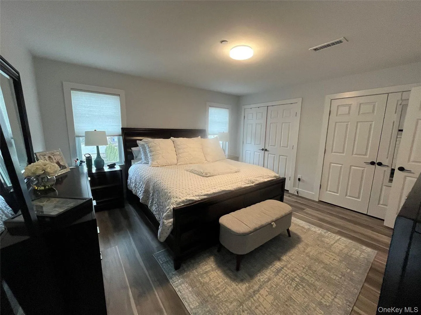 Bedroom with two closets and dark wood-style floors Bedroom with two closets and dark wood-style floors