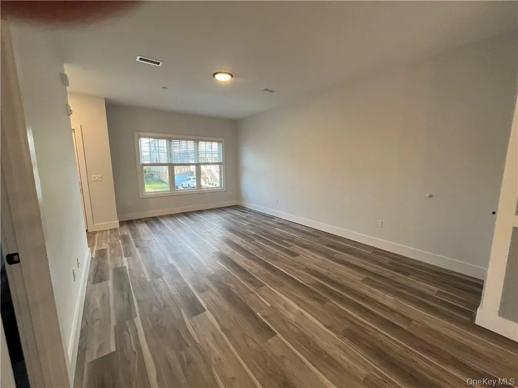 Unfurnished room featuring dark wood-type flooring and baseboards Unfurnished room featuring dark wood-type flooring and baseboards