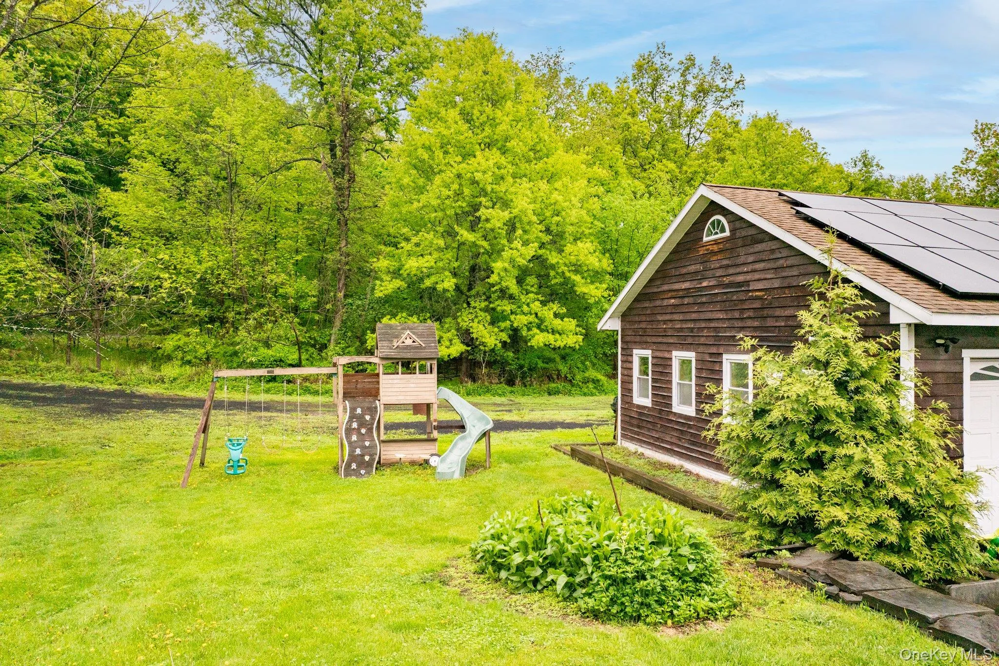 View of green lawn with a playground View of green lawn with a playground