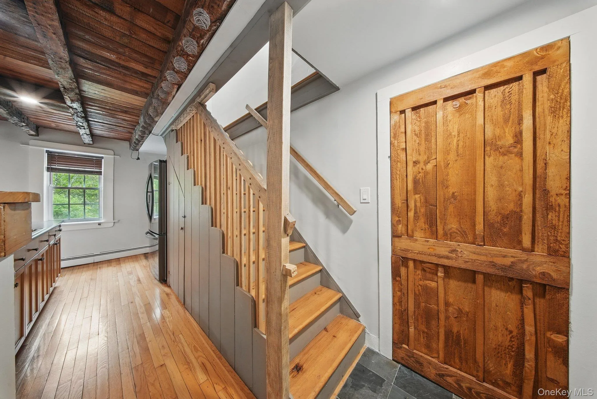 Staircase with hardwood / wood-style floors, baseboard heating, and wood ceiling Staircase with hardwood / wood-style floors, baseboard heating, and wood ceiling