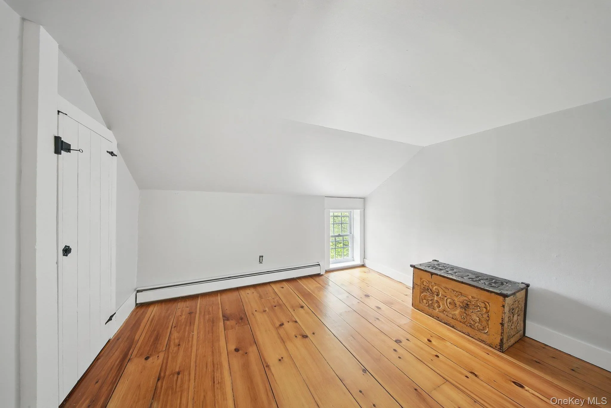 Bonus room featuring vaulted ceiling, a baseboard heating unit, and light wood-type flooring Bonus room featuring vaulted ceiling, a baseboard heating unit, and light wood-type flooring