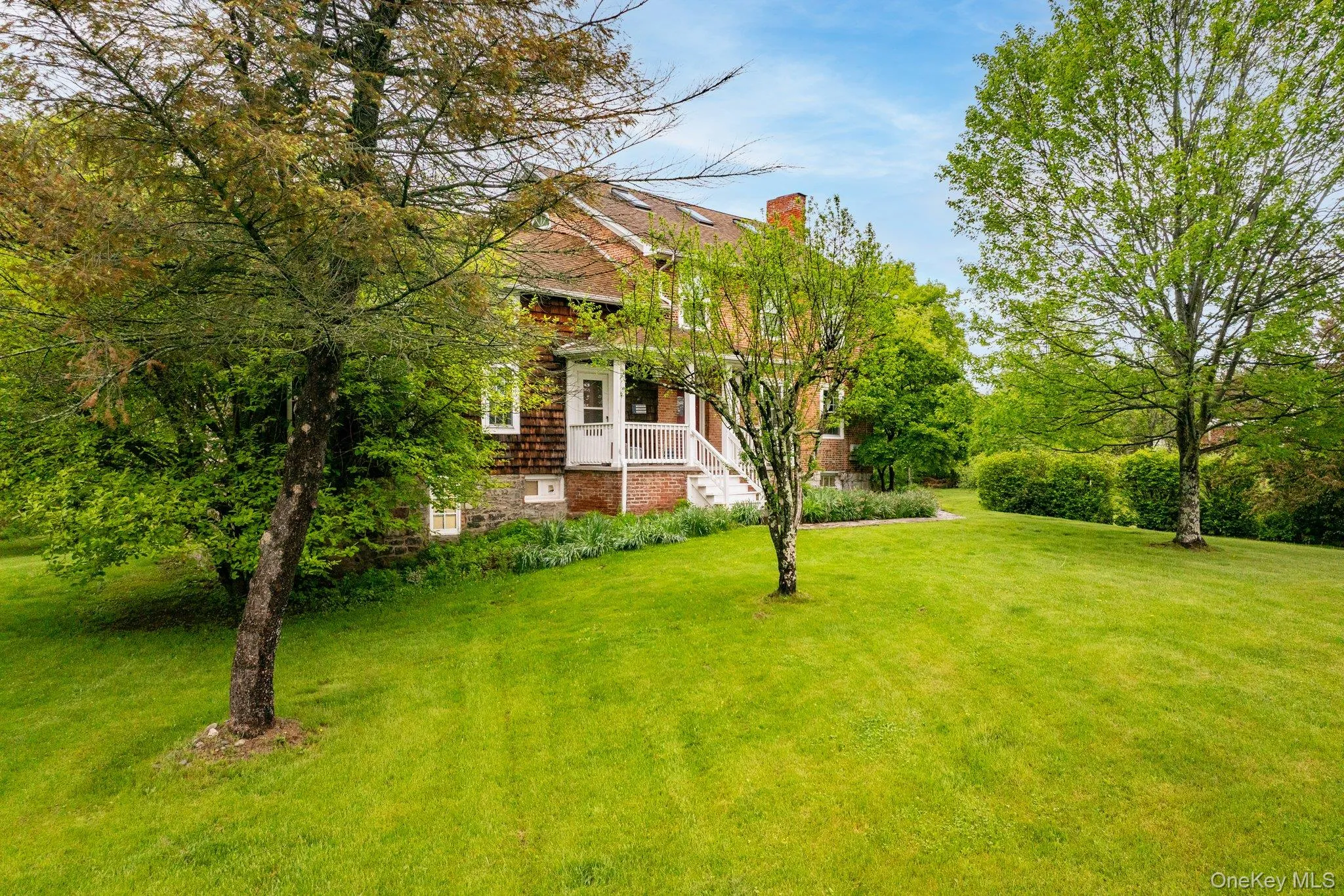View of green lawn featuring a porch View of green lawn featuring a porch